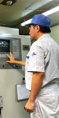 木谷電器株式会社 一日の仕事｜技術 T.Y.さんがCNC機械の操作パネルを操作する様子