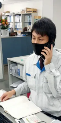 木谷電器株式会社 一日の仕事｜営業 Y.K.さんがオフィスで電話対応しながら書類確認する様子